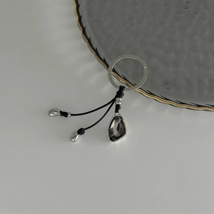 Detail of vintage key ring with charcoal grey faceted gemstone and braided cord