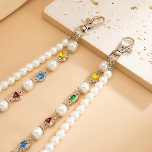 Detail of cross pendant belt chain featuring imitation pearls and colorful gemstones with rhinestones