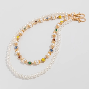 Detail of beaded waist chain with faux pearls, colorful crystal charms and gold clasps