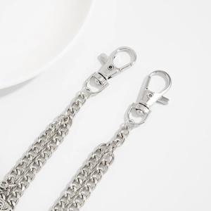 Detail of silver double-layered metal trousers chain with moth skull pendants and lobster clasps