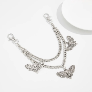 Detailed macro view of vintage silver double-layer punk chain with moth and skull pendants