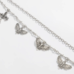 Detail of gothic moth and skull pendants on multi-layer silver metal chains