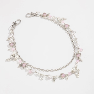 Detail van zilveren ketting met roze kralen, hartvormige hangers en strikjes