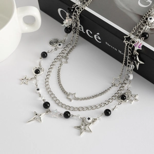 Macro-opname van de Y2K-stijl gelaagde ketting met ster- en hart hangers en kralen