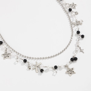 Detail van de Y2K ster hanger en kralen op een dubbellaagse denim heupketting