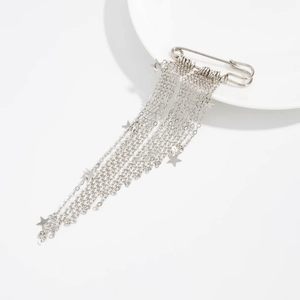 Gros plan de la broche à glands argentée avec pendentifs étoiles sur fond blanc
