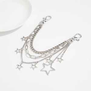 Detail of layered silver metal chain with hollow star charms and lobster clasps