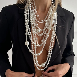 Gros plan du collier de perles blanches multicouche sur mannequin avec blazer noir