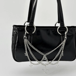 Black glossy leather handbag featuring star charms and silver metal chain tassels