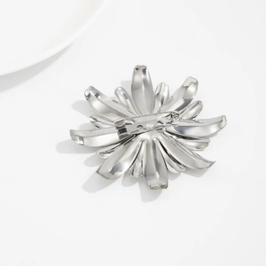Vue macro de la broche fleur argentée irrégulière montrant le fermoir au dos du bijou