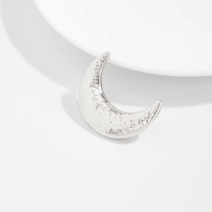 Détail de la broche lune argentée avec une texture martelée irrégulière moderne