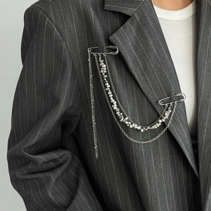 Silver punk style double pin brooch with long chain tassels on a grey pinstripe blazer suit