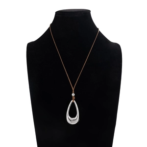 Primer plano de colgante de gota en plata pulida con cordón marrón en busto negro