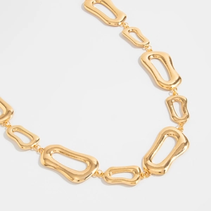 Detail shot of irregular hollow geometric gold waist chain links with high-polished finish