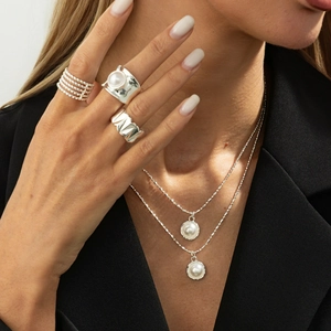 Minimalistische silberne Metallhalskette mit Perlen und passenden Ringen am Model
