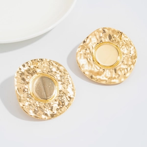 Detailed view of large gold-plated disc earrings with hammered texture edges and smooth centers