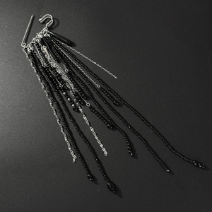 Detail of silver safety pin brooch with black crystal beads and long fringe chain tassels