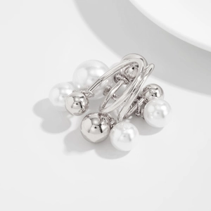 Detailed close-up of layered silver metallic beads and white faux pearl charms on the ring