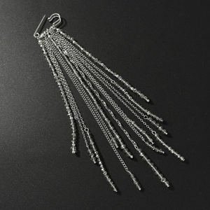 Detailed view of multilayer silver chains and dark grey crystal bead fringe on a safety pin brooch