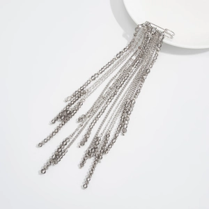 Detail of silver safety pin brooch featuring long beaded tassels and grey crystal chains