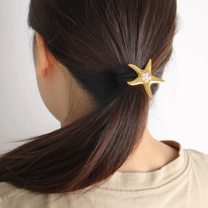 Close-up of golden starfish hair tie with pearls on a high-elastic ponytail band