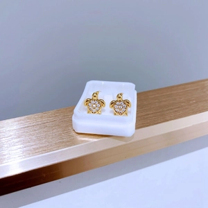 Detailansicht goldener Schildkröten-Ohrstecker mit Zirkonia-Inlay in einem kleinen Etui