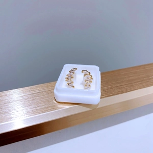Detail von vergoldeten gebogenen Ohrsteckern mit Zirkonia im Marquise-Schliff in Box