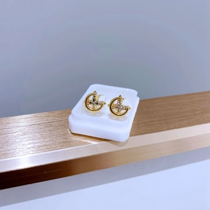 Nahaufnahme von goldenen Halbmond- und Kreuzohrringen mit funkelnden Zirkonia-Steinen