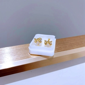 Nahaufnahme der herzförmigen Kristallohrringe mit Goldschleife und Schraubverschluss