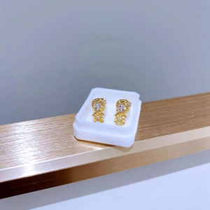 Detailansicht der goldenen Comic-Mädchen-Ohrstecker mit weißen Zirkonen in der Displaybox