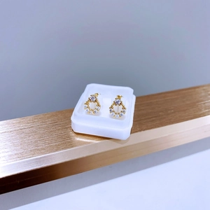 Detailansicht goldener Ohrringe aus Titanstahl mit Zirkon-Inlay in Geschenkbox