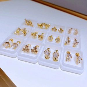 Set aus goldenen Titanstahl-Ohrringen mit Zirkonia-Blumen und Schmetterlingen in Boxen