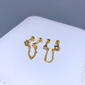 Nahaufnahme goldener Kettenohrringe mit Sternformen und bunten Zirkonia-Details