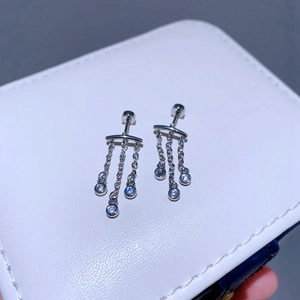 Detailaufnahme von Titanstahl Kettenohrringen mit blauen Zirkonia auf einer Box
