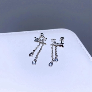 Detail von silbernem Schmetterling Ohrring mit Kettenquasten und Zirkonsteinen