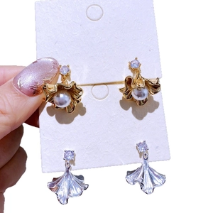 Goldene und silberne Ginkgoblatt-Ohrringe mit Perlen und Zirkon auf Displaykarte
