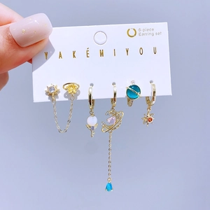 Dettaglio di un set da 6 orecchini dorati con cristalli colorati e motivi celestiali
