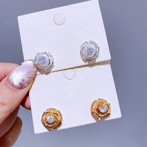 Makro-Detail von Vintage-Hohlblumen-Ohrringen in Gold und Silber mit Zirkonia-Steinen