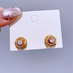 Exquisite goldene hohle Rosen-Ohrstecker mit einem funkelnden zentralen Zirkonstein