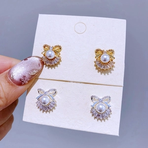 Detailansicht der Perlen-Ohrstecker mit Schleife in Gold und Silber mit Zirkon-Steinen