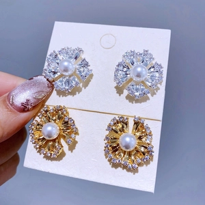 Detaillierte Ansicht blumenförmiger Ohrstecker mit Zirkonia und Perlen in Gold und Silber