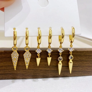 Detailed view of three pairs of gold-plated hoop earrings with cubic zirconia charms
