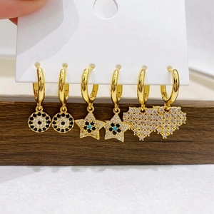 Detailed set of three gold earrings featuring star, heart, and evil eye charms with zircons