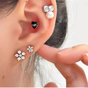 Detailansicht der Doppel-Ohrring-Kette mit Blumenkristallen und schwarzem Liebesherz-Stecker