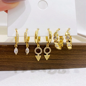 Detailed set of three gold-plated earrings with zircon stones on a white display card
