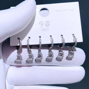Makro-Detail von S925 Silber-Ohrringen als Dinosaurier mit weißen Zirkonia-Steinen