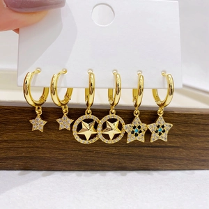 Detail of six gold-plated hoop earrings with micro-inlaid zircon star charms on display
