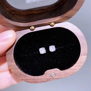 Makroaufnahme von Zirkonia-Ohrsteckern in einer hochwertigen Schmuckbox aus Holz