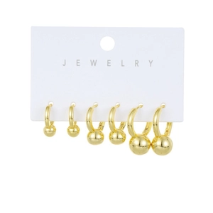 Three pairs of golden hoop earrings with tiered metal ball pendants on a jewelry card