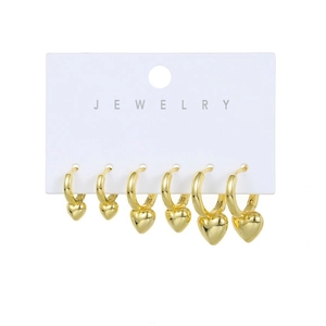 Three pairs of gold-plated hoop earrings with heart charms on jewelry display card